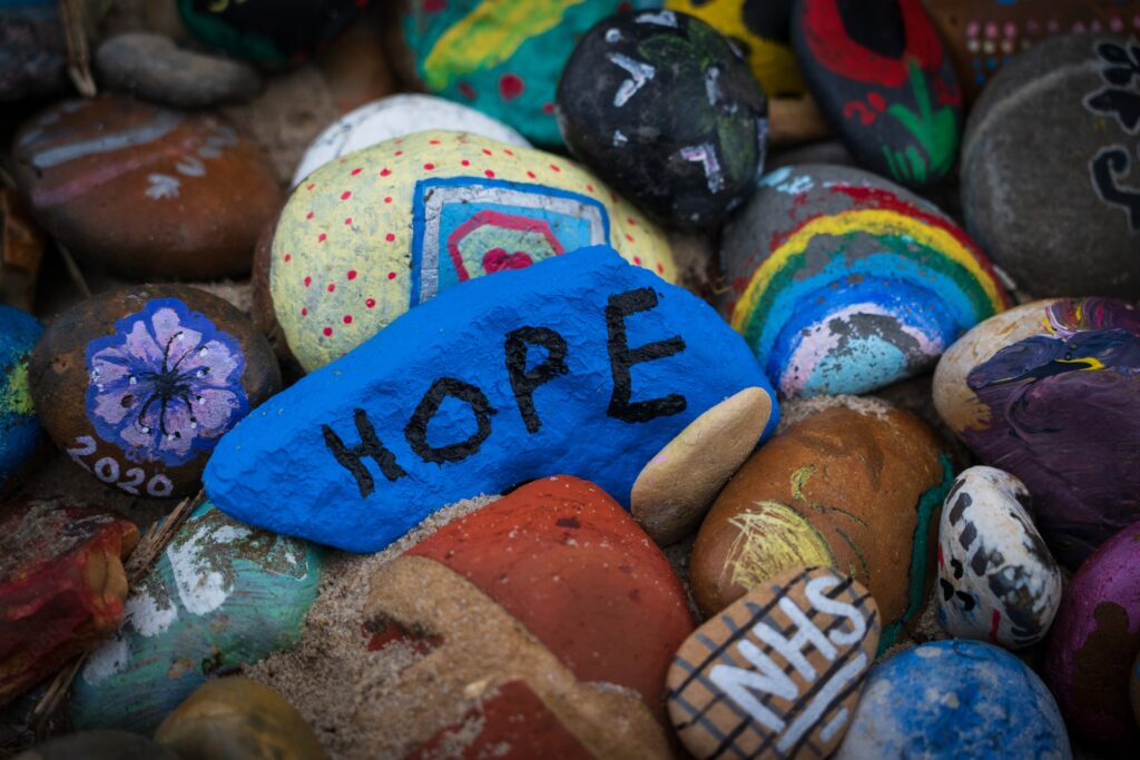 Painted pebbles, one in focus says hope